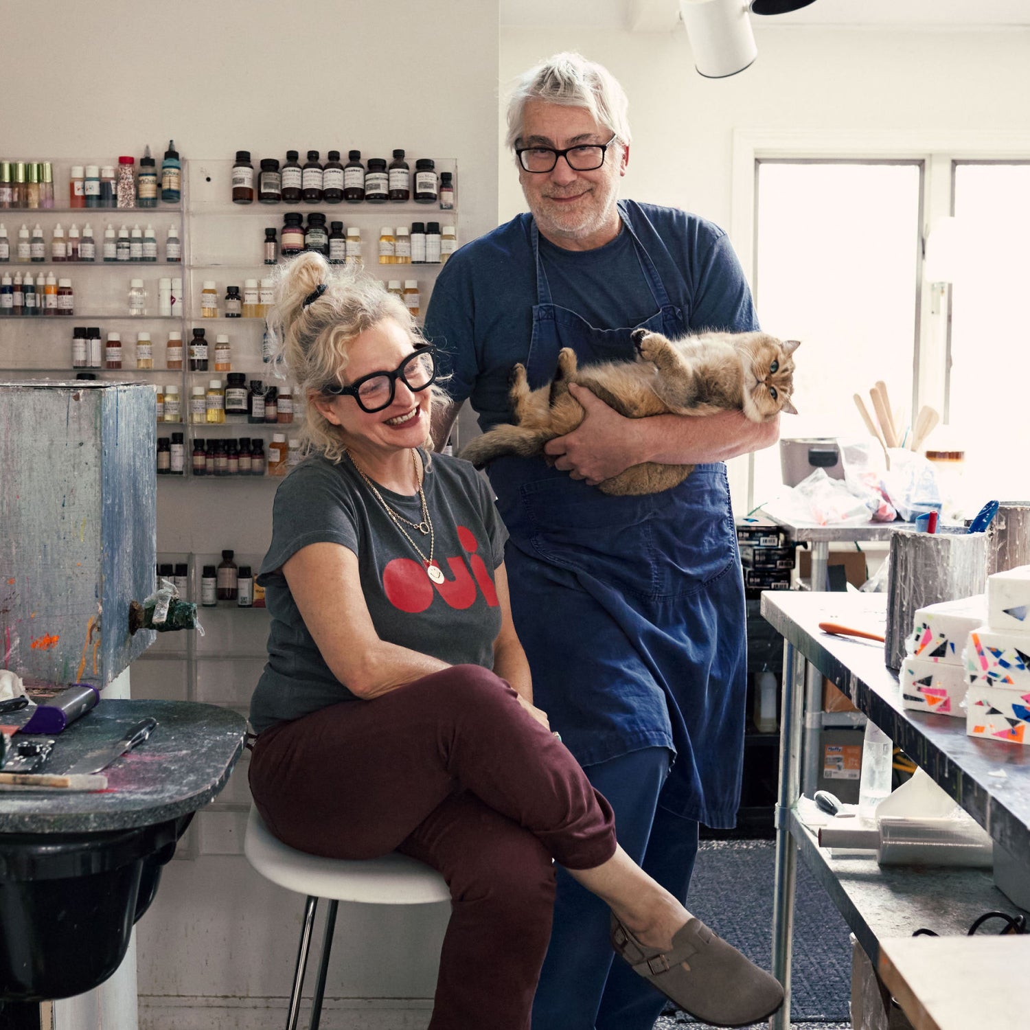 Linda and John Meyers at home in their workshop with their pet cat.