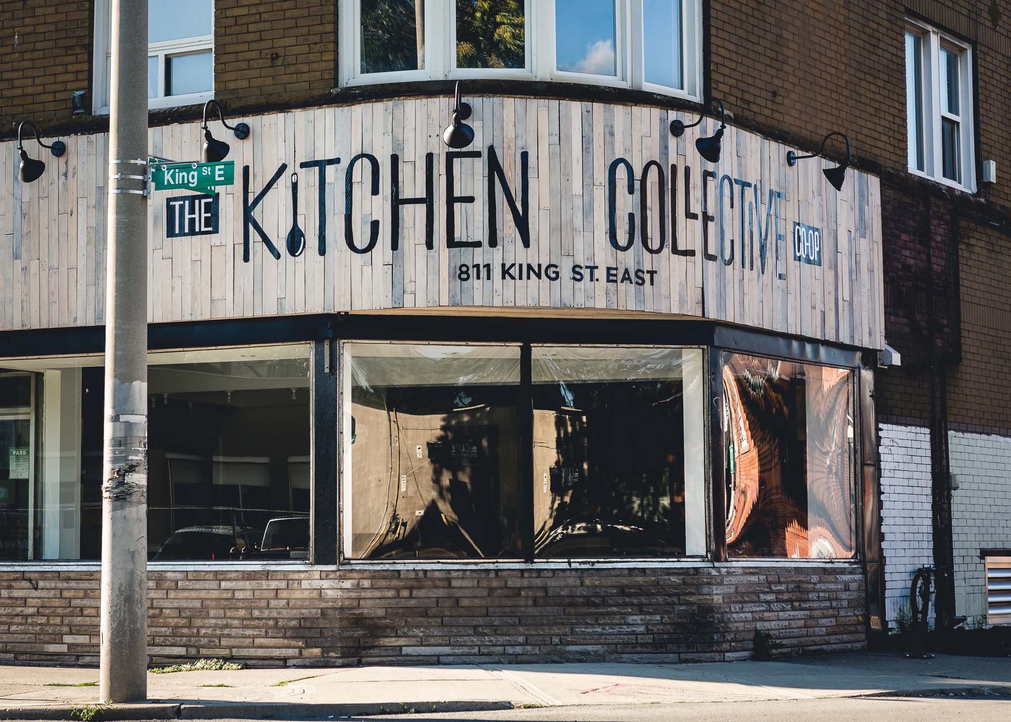 Exterior of The Kitchen Shopify Collective building with signage on corner street.